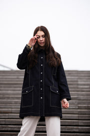 a lady weraing a wide denim coat with large pockets