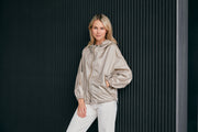 woman wearing a contemporary beige windbreaker jacket with hood