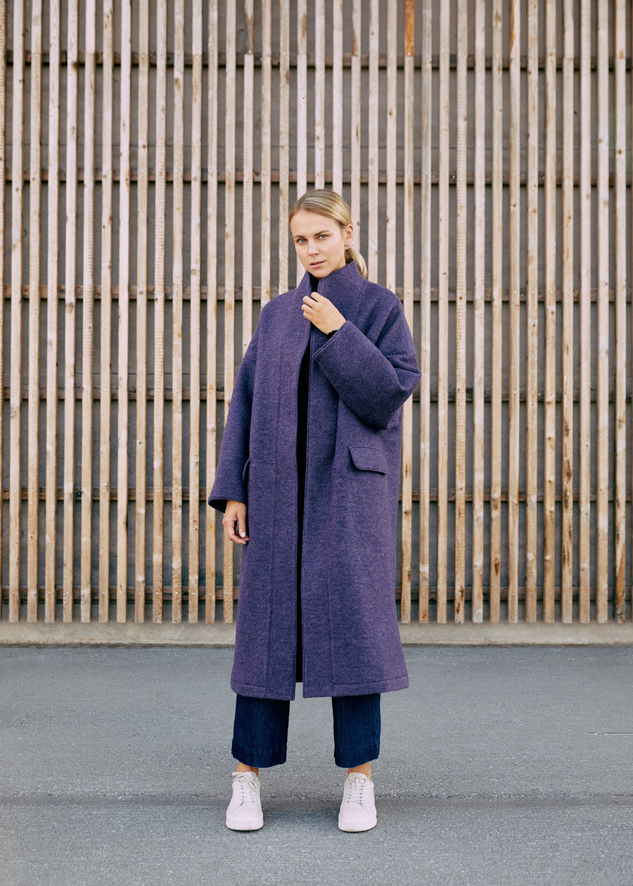 A lady wearing a dark purple wool coat for winter 