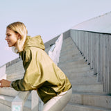 Woman wearing a hooded windbreaker jacket in green color 