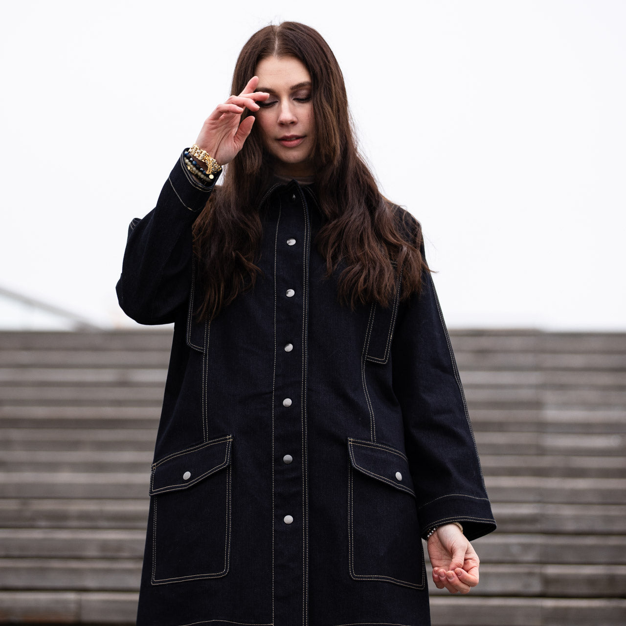 a lady weraing a wide denim coat with large pockets 