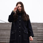 a lady weraing a wide denim coat with large pockets 