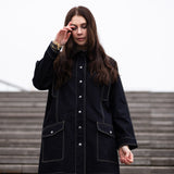 a lady weraing a wide denim coat with large pockets 