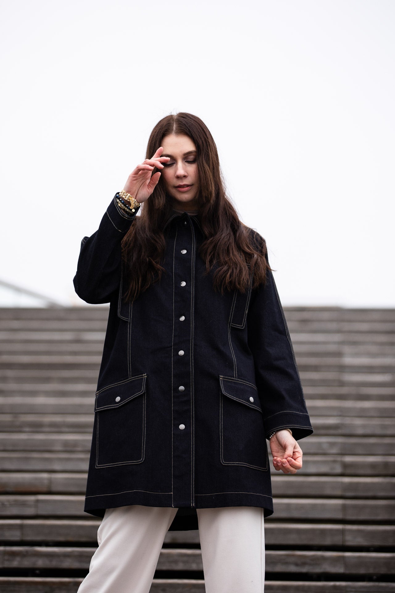 a lady weraing a wide denim coat with large pockets 