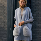 Woman wearing a grey merino knit vest with fox fur pockets 