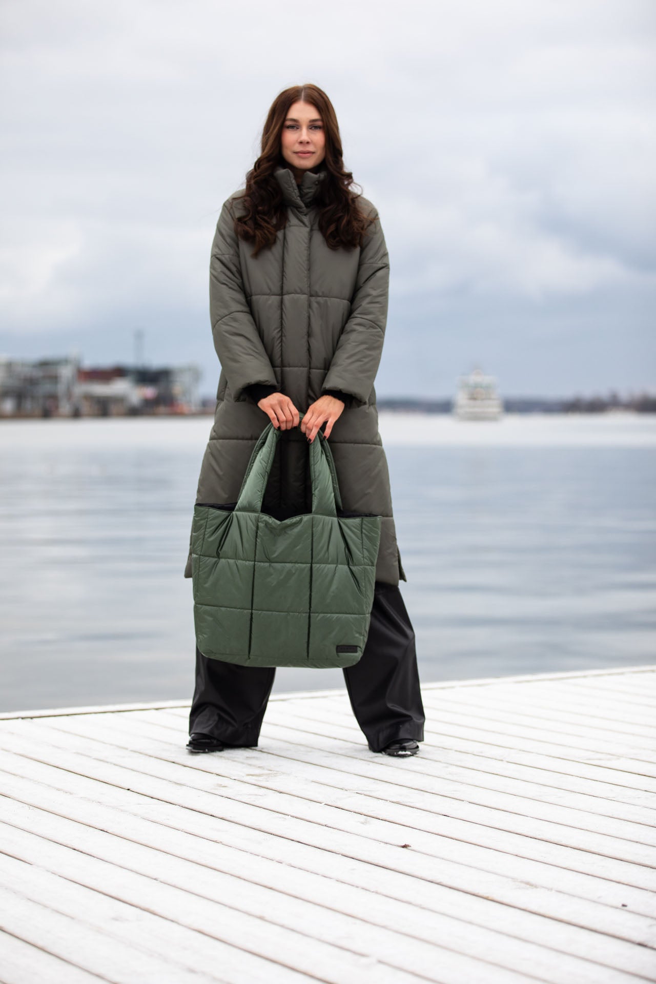 A woman holding a large olive green tote bag 
