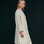 Woman wearing a light quilted coat in a nice light yellow color 