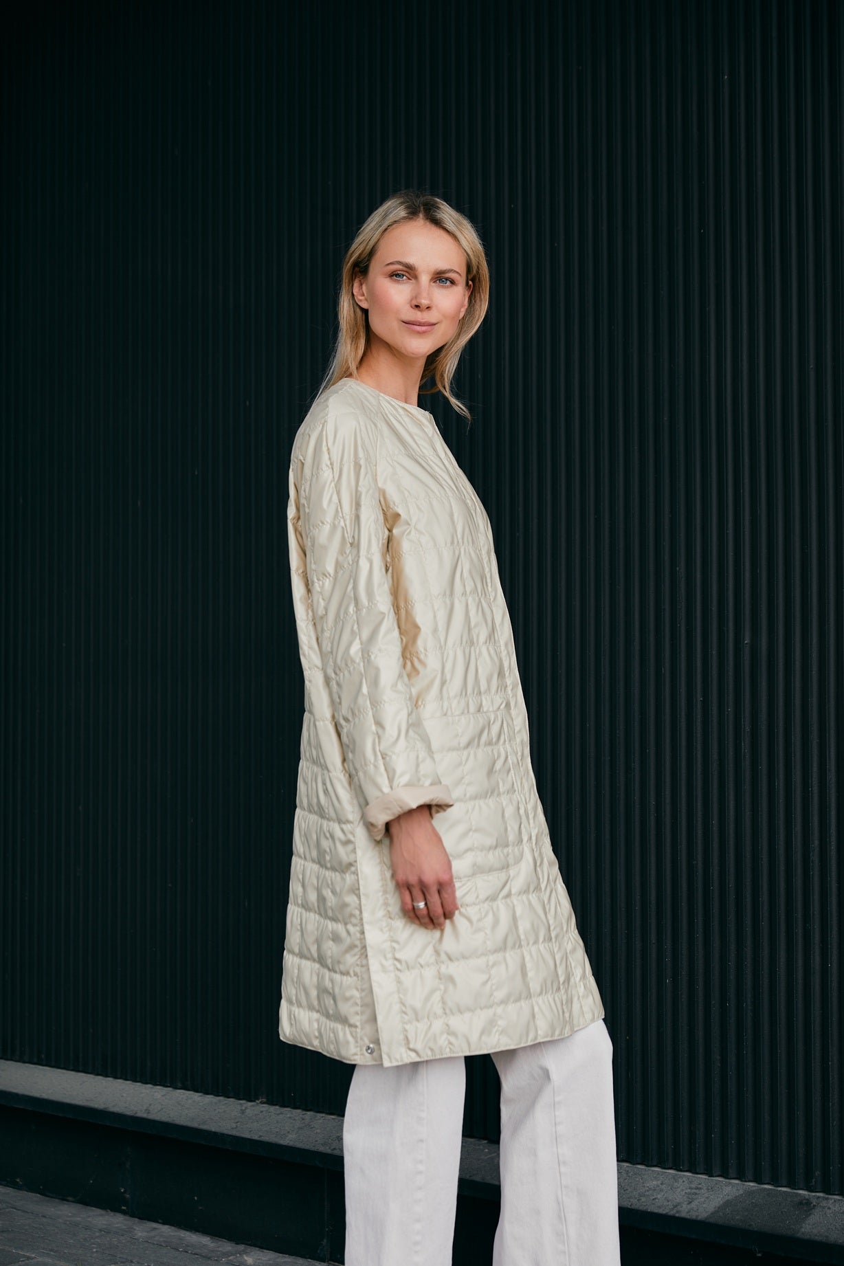 Woman wearing a light quilted coat in a nice light yellow color 