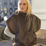 Woman wearing a brown puffer vest in an urban setting