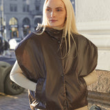 Woman wearing a brown puffer vest in an urban setting
