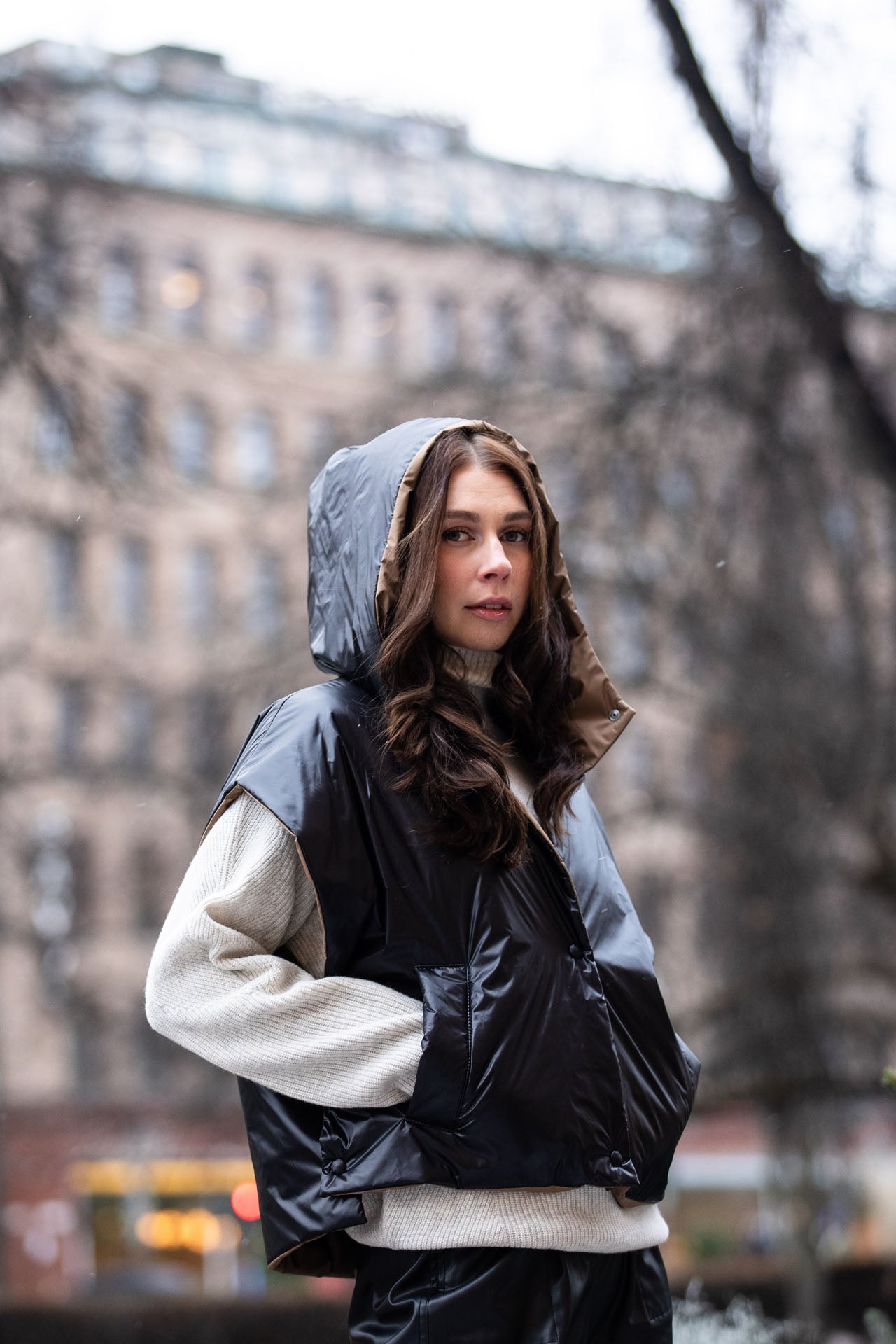 woman wearing a cropped light puffer gilet with hood 
