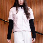 a woman wearing a light padded jacket with short sleevs and zipper closing 