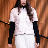 a woman wearing a light padded jacket with short sleevs and zipper closing 