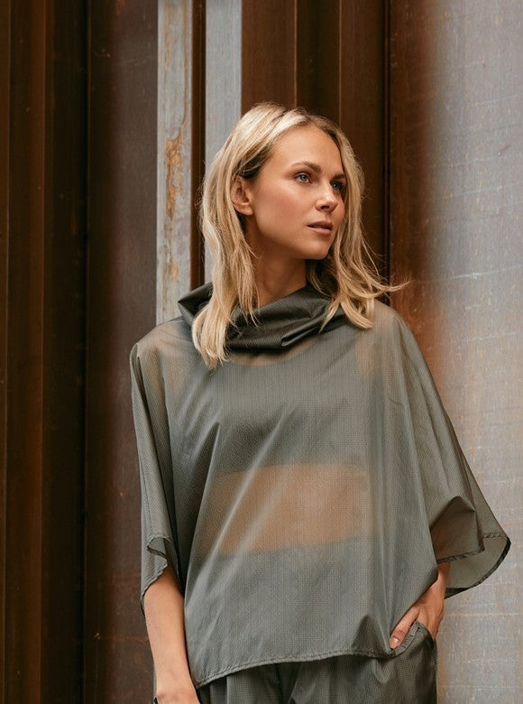 woman wearing a sheer windbreaker poncho 