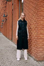 a lady wearing a long vest made from denim fabric 