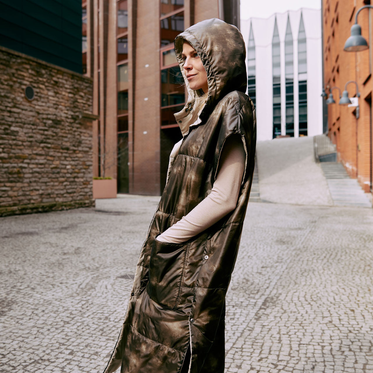 A lady wearing an ultralight warm puffer vest that is reversible and  easy to wear 