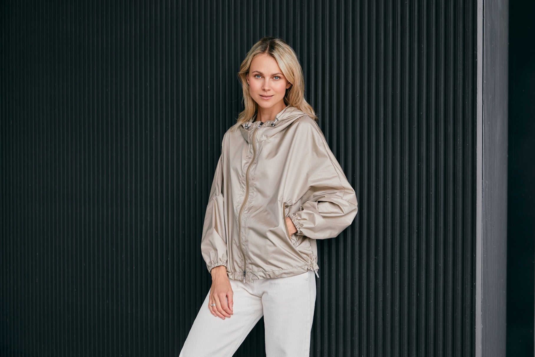 woman wearing a contemporary beige windbreaker jacket with hood  