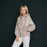 woman wearing a contemporary beige windbreaker jacket with hood  