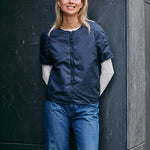 woman wearing a light padded jacket with zipper closing and short sleeves 