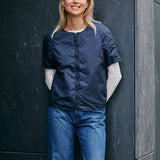 woman wearing a light padded jacket with zipper closing and short sleeves 