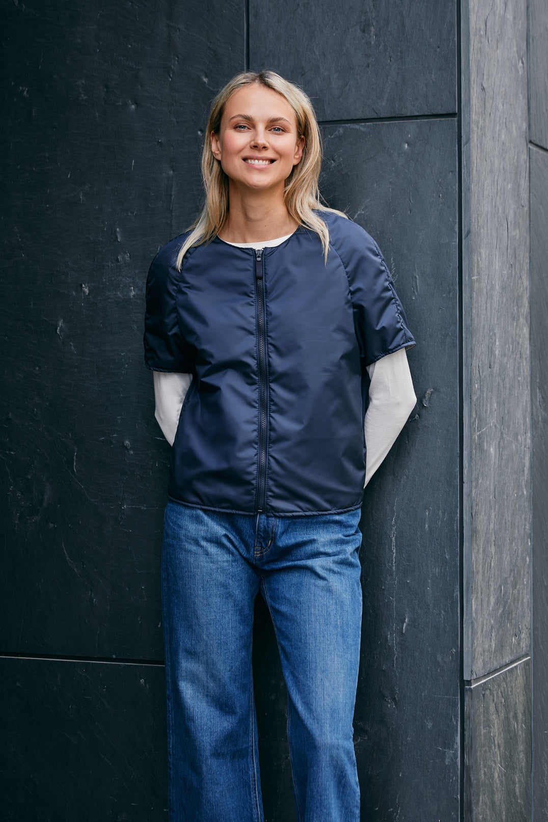 woman wearing a light padded jacket with zipper closing and short sleeves 