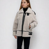 A woman wearing a white shrearling jacket 