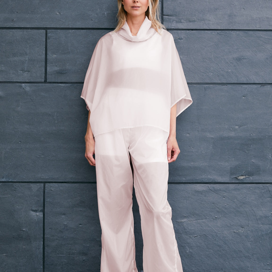 woman wearing a light windbreaker set with poncho and pants suitable for Summer 