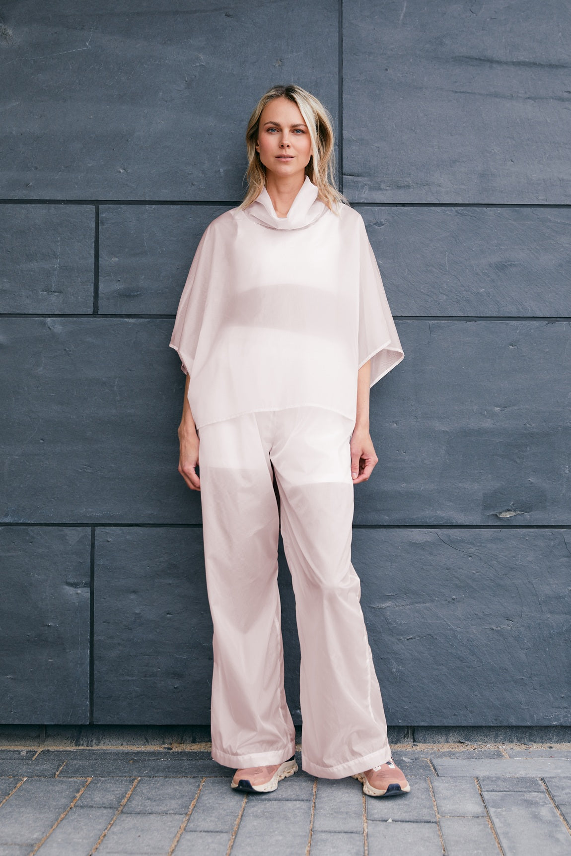 woman wearing a light windbreaker set with poncho and pants suitable for Summer 