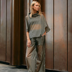 Woman wearing light, sheer green windbreaker poncho and pants 