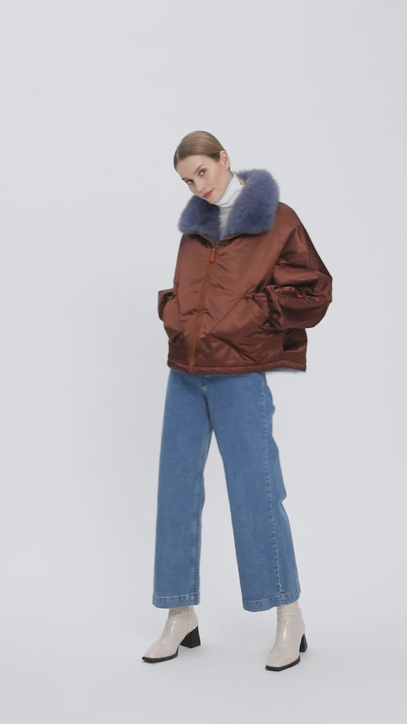 A reversible bomber-style jacket, with luxurious fox fur lining.  The left sleeve on both sides has a pocket with zipper, perfect for the ski lift card. The jacket has a loose fit and hood has a fox fur trim in a contrasting color.