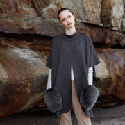 Lady modelling a knitted merino poncho with luxurious fox fur pockets