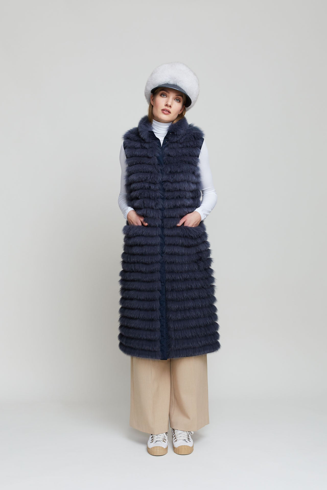 Women's long reversible fox fur vest with features fur pockets in a contrasting colour.