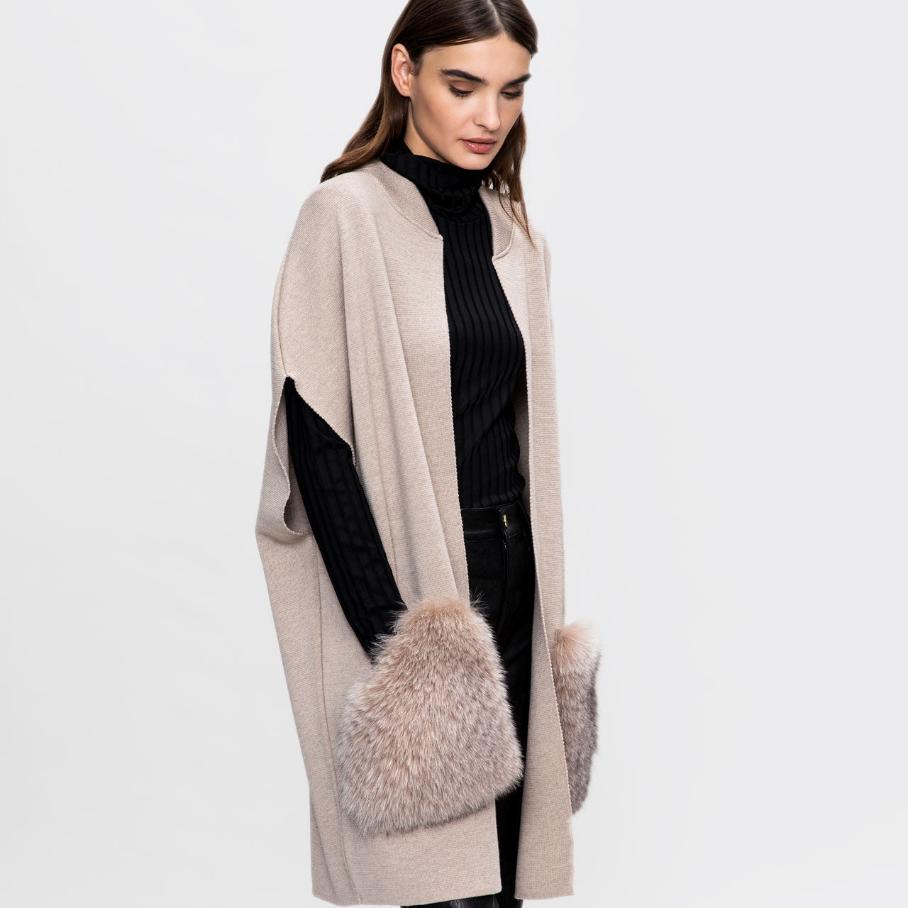 A tall model wearing A knitted classical merino vest with large fox fur pockets