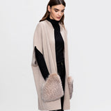 A tall model wearing A knitted classical merino vest with large fox fur pockets