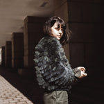A woman wearing a fox fur bomber jacket with camo-look