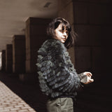 A woman wearing a fox fur bomber jacket with camo-look