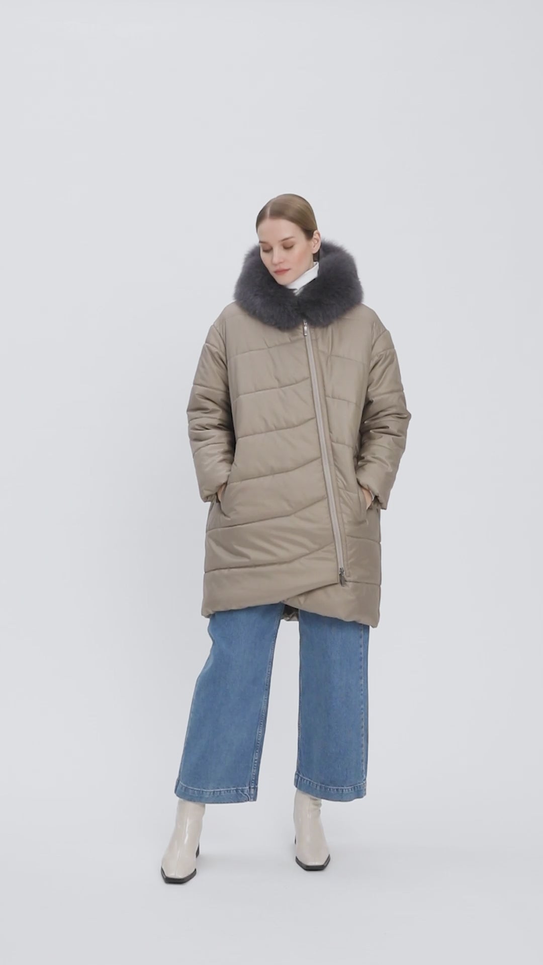 Young-lady-modelling-a-puffer-coat-has-a-rounded-back-an-asymmetric-front-zipper-and-two-side-pockets